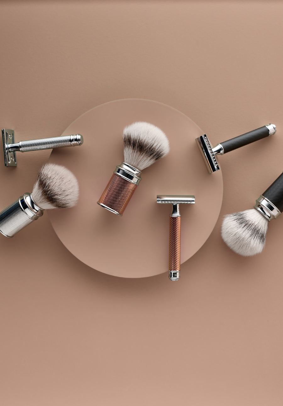 shaving brushes and safety razors with metal handles placed on a beige background.