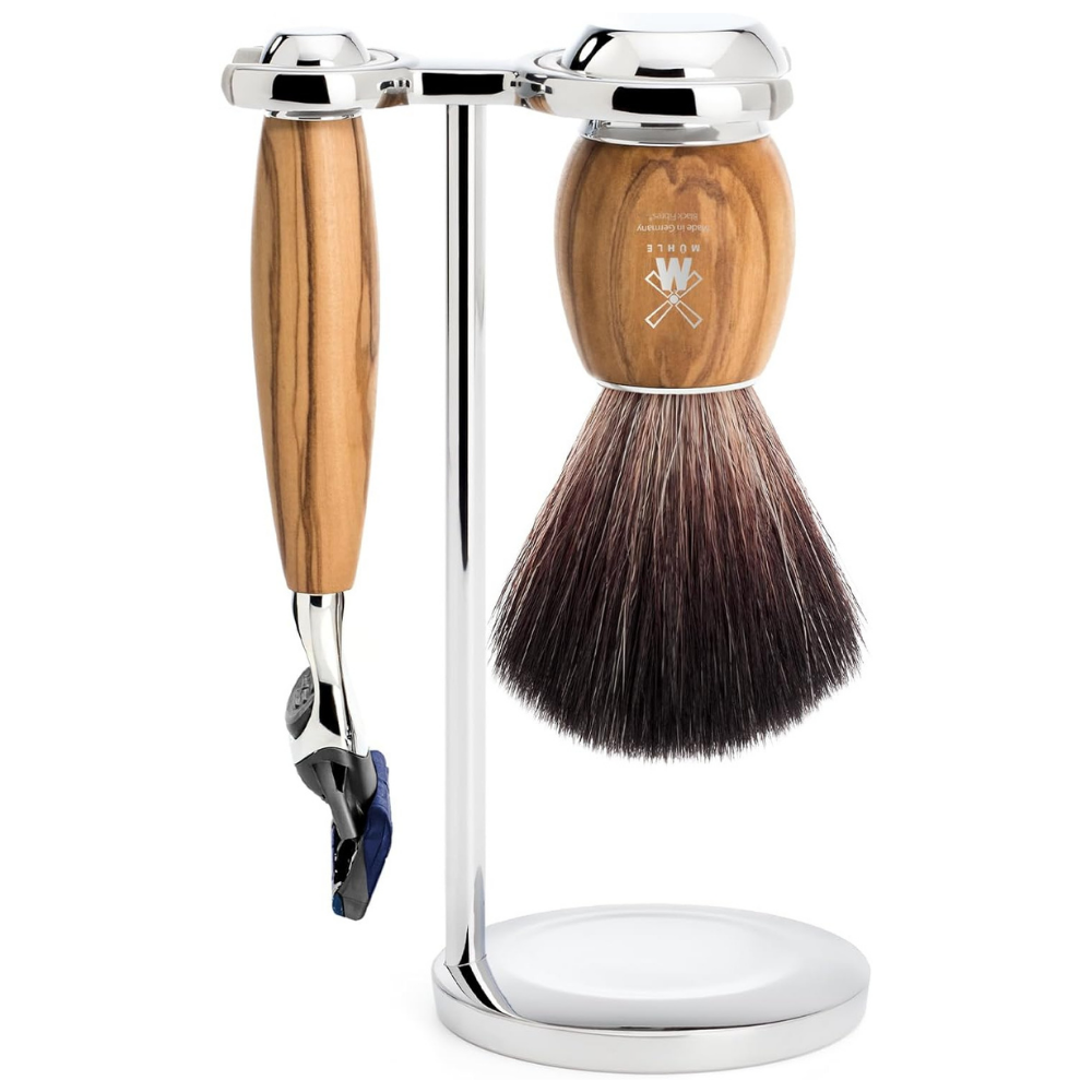 Shaving brush and razor with a wooden handle and silver stand on a white background