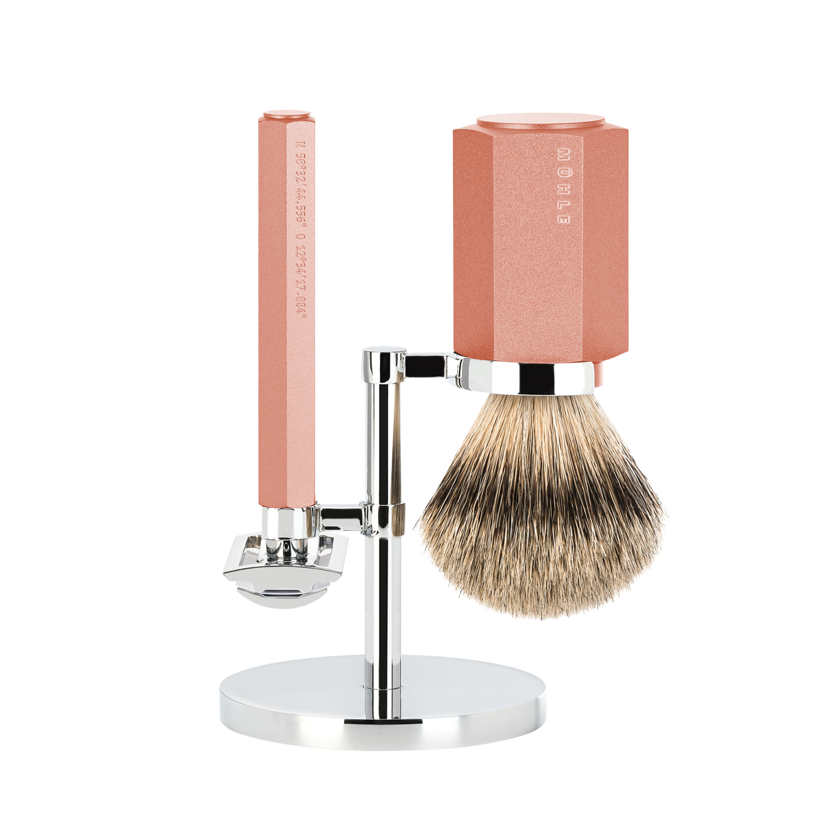 A three-piece shaving set consisting of a silvertip badger brush and a safety razor with a pink handle on a metal stand, all displayed against a white background.