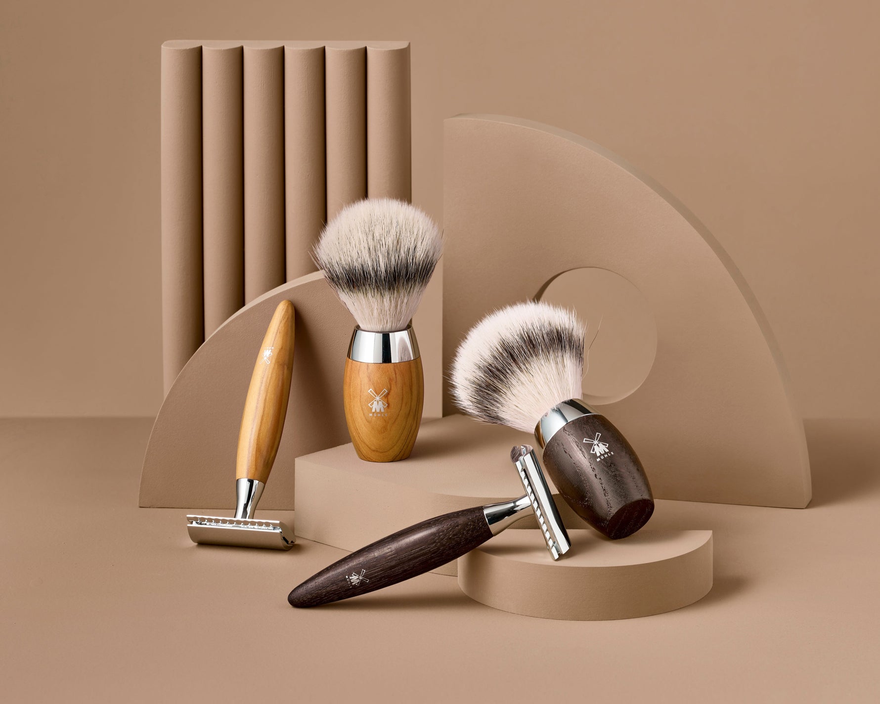 Set of shaving brushes and razors with wooden handles on a beige background
