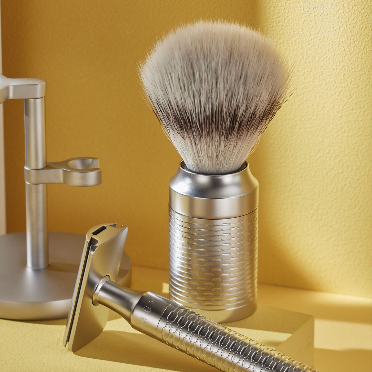 Shaving brush and razor on a yellow background
