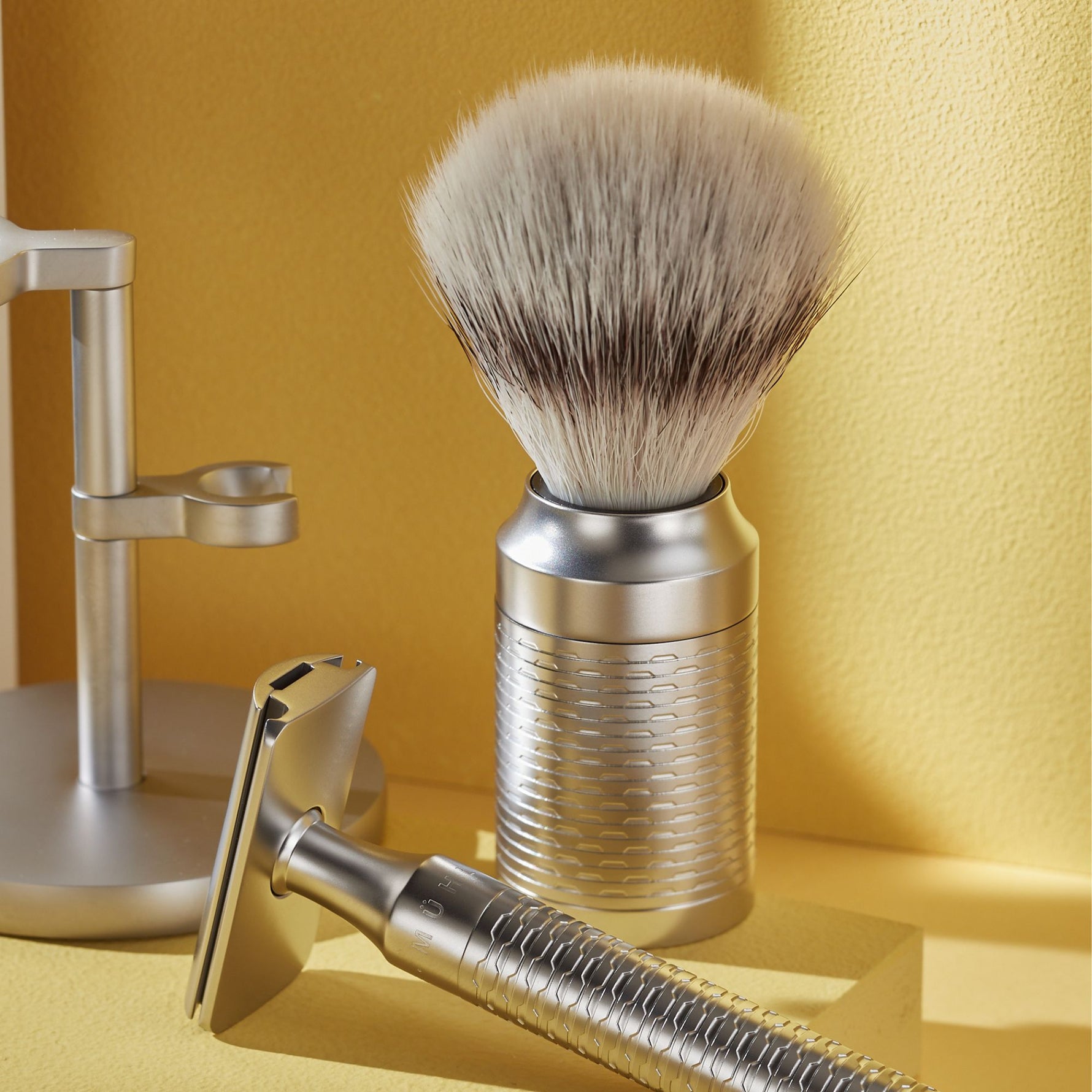 Shaving brush and razor on a yellow background