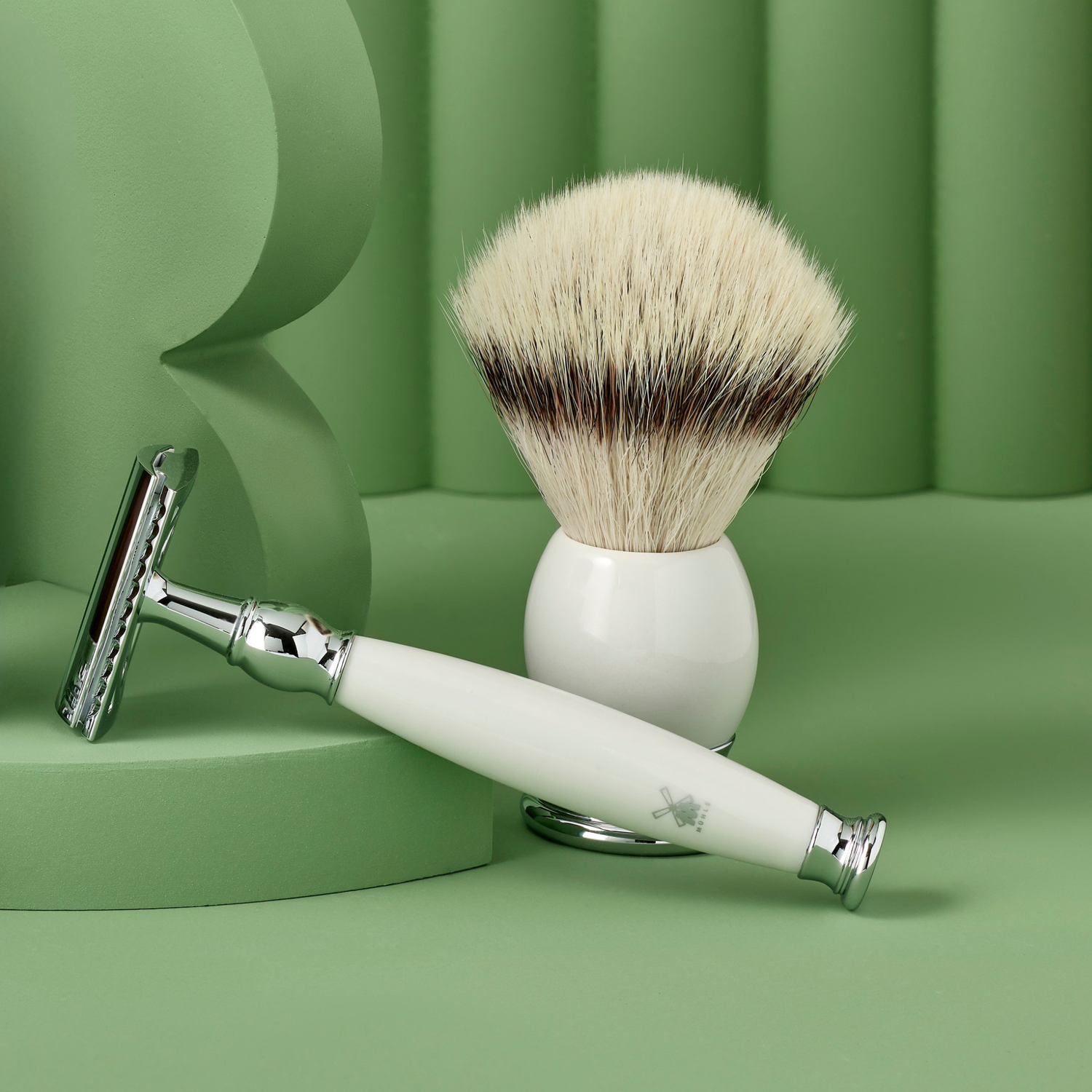 Shaving brush and razor on a green background