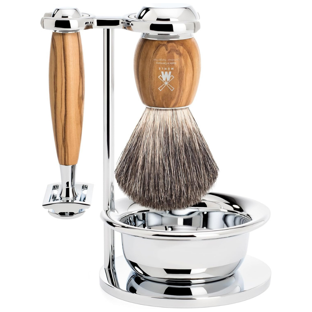 Shaving brush and razor with a wooden handle, silver stand and silver metallic shaving bowl on a white background