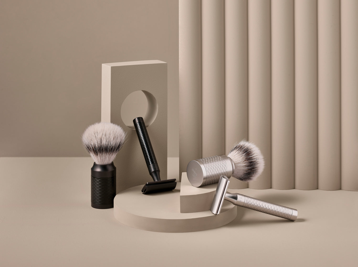 Set of shaving brushes with matching handles on a neutral background